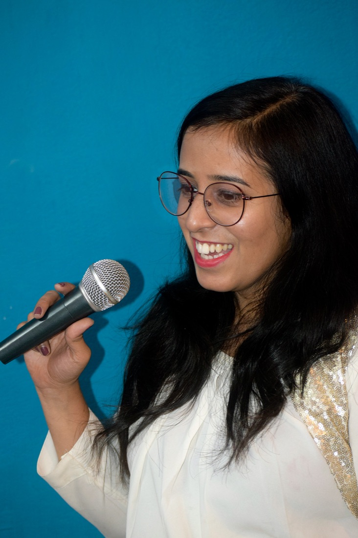 Portrait of Aprajeeta Singh speaking into a microphone